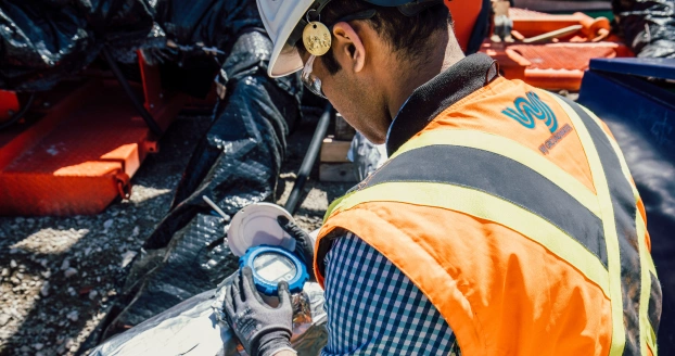 Worker inspecting equipment in safety gear.