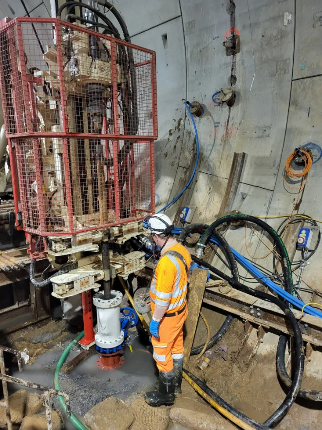 Worker operating drilling equipment underground. Northolt Tunnel West - dewatering