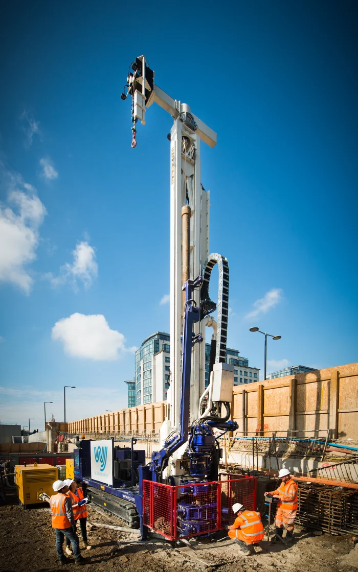 Construction workers operating drilling equipment. well drilling